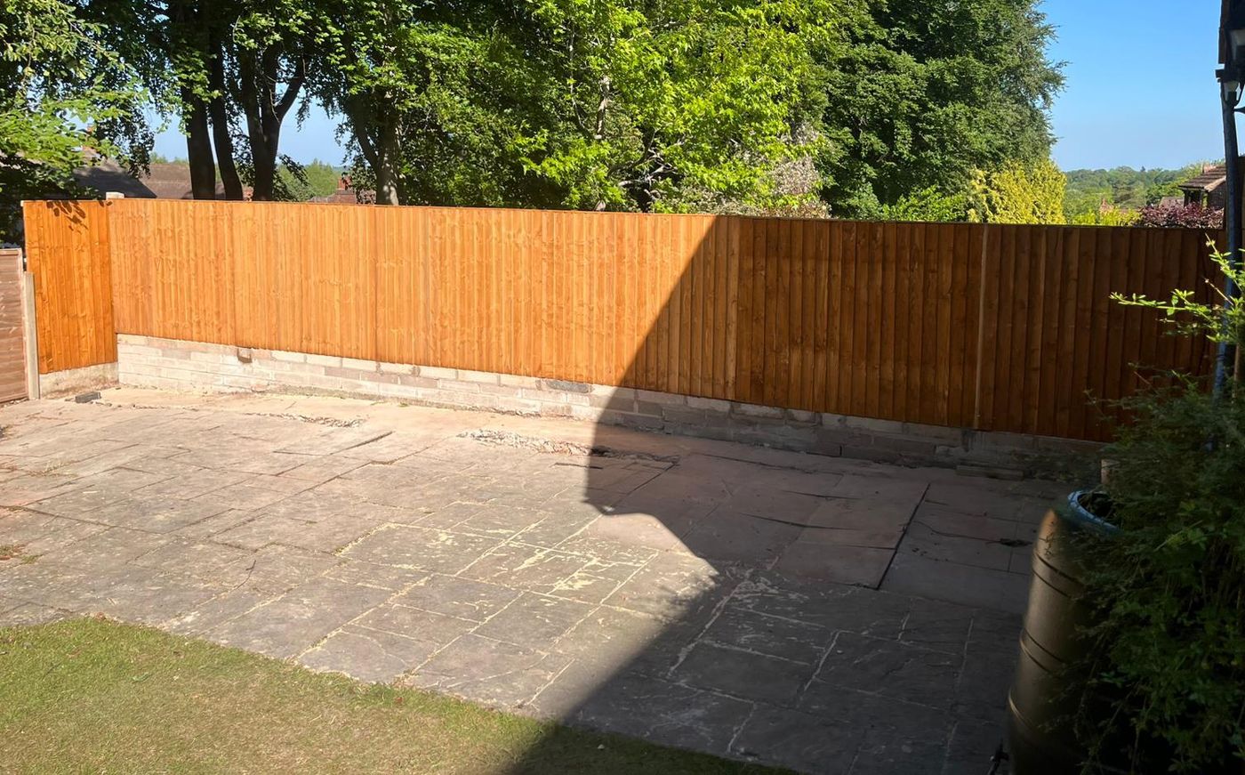 New closeboard fence on a brick base around a garden patio