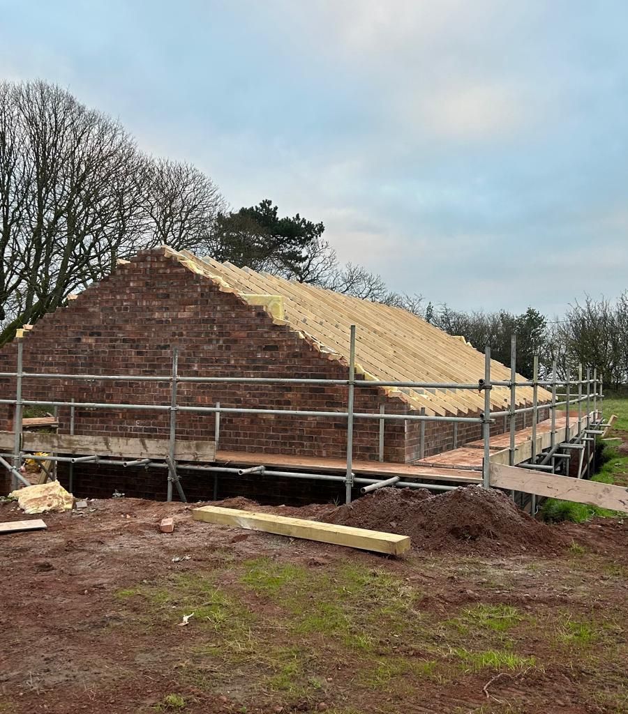 New brick gable end with roof rafters fitted, on scaffold