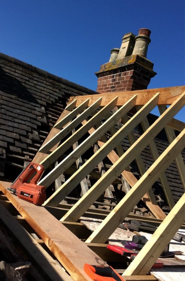 New timber rafters for a dormer on a tiled roof beside a chimney