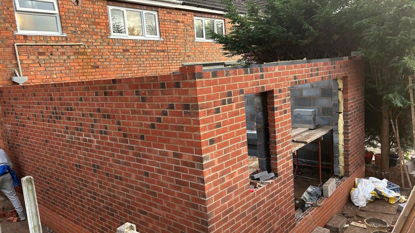 Rear extension walls in red and black multi brick with window openings