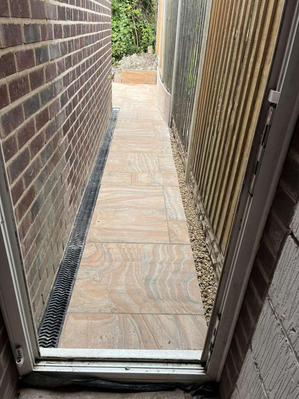 Porcelain side path with a linear channel drain along the house wall